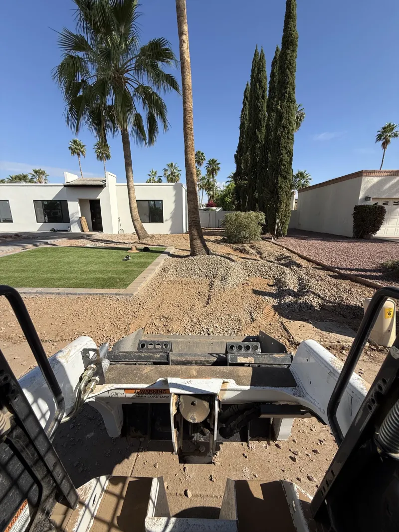 Skid steer grading a front yard for landscaping and concrete work, yard grading Phoenix AZ