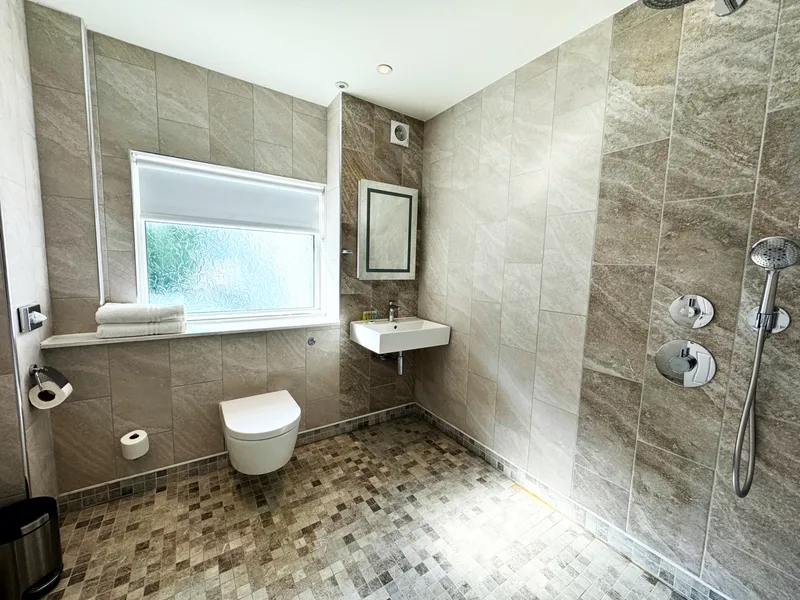 A wet room at The Fig Tree Hotel, with a level floor and no shower tray to step over