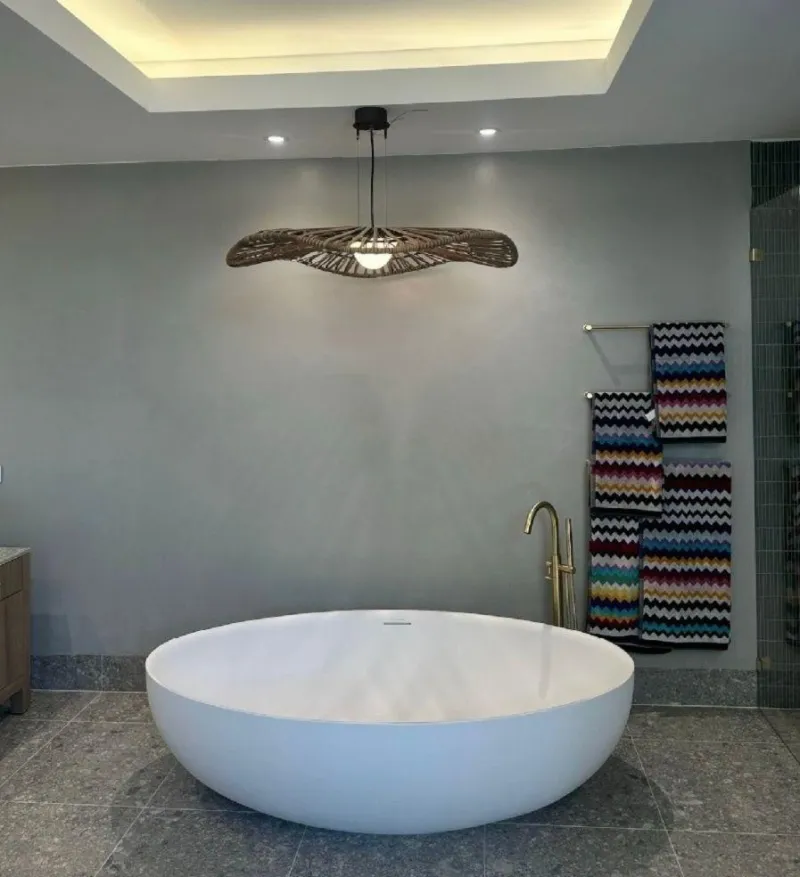 Round freestanding bath with a floor mounted brass filler