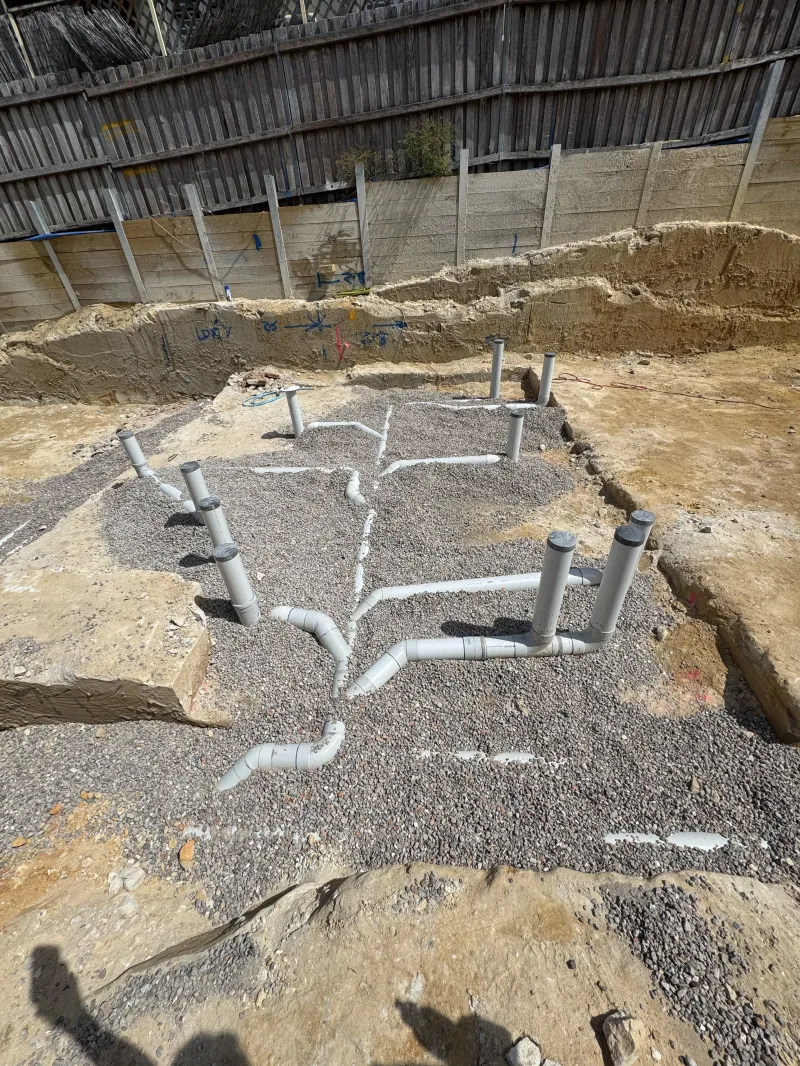 New drainage pipework laid in gravel on a building site