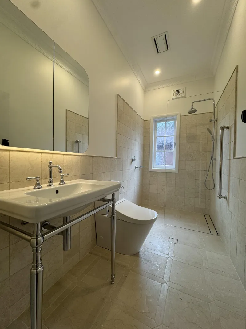 Completed bathroom with basin, toilet and walk in shower