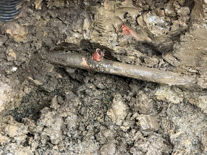 Copper water pipe uncovered in a wet excavation