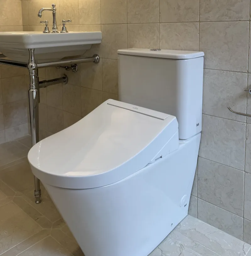 Toilet suite and basin installed in a tiled bathroom