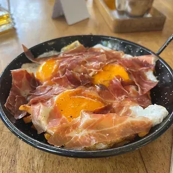 Huevos rotos con papás y jamón serrano