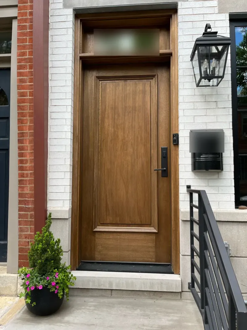 Refinished wood front door on a white brick row home