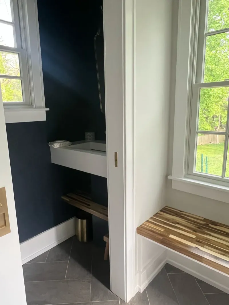 Bathroom with gray tile floor, floating vanity and navy walls