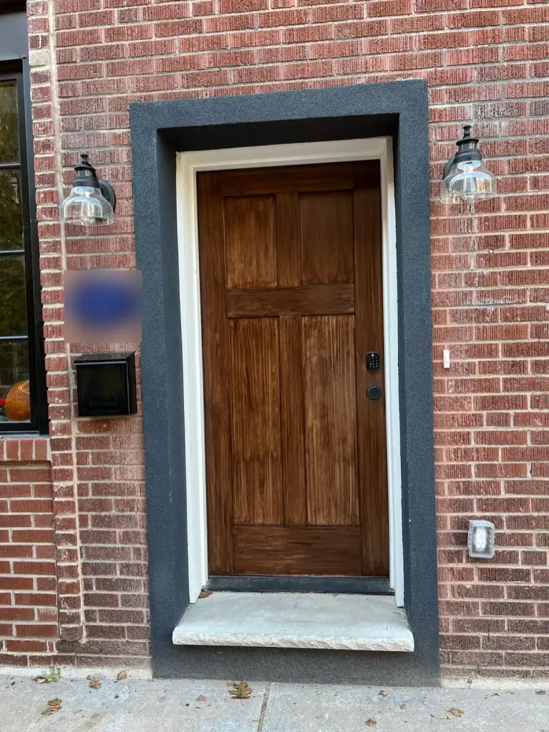 Refinished wood front door on a brick row home