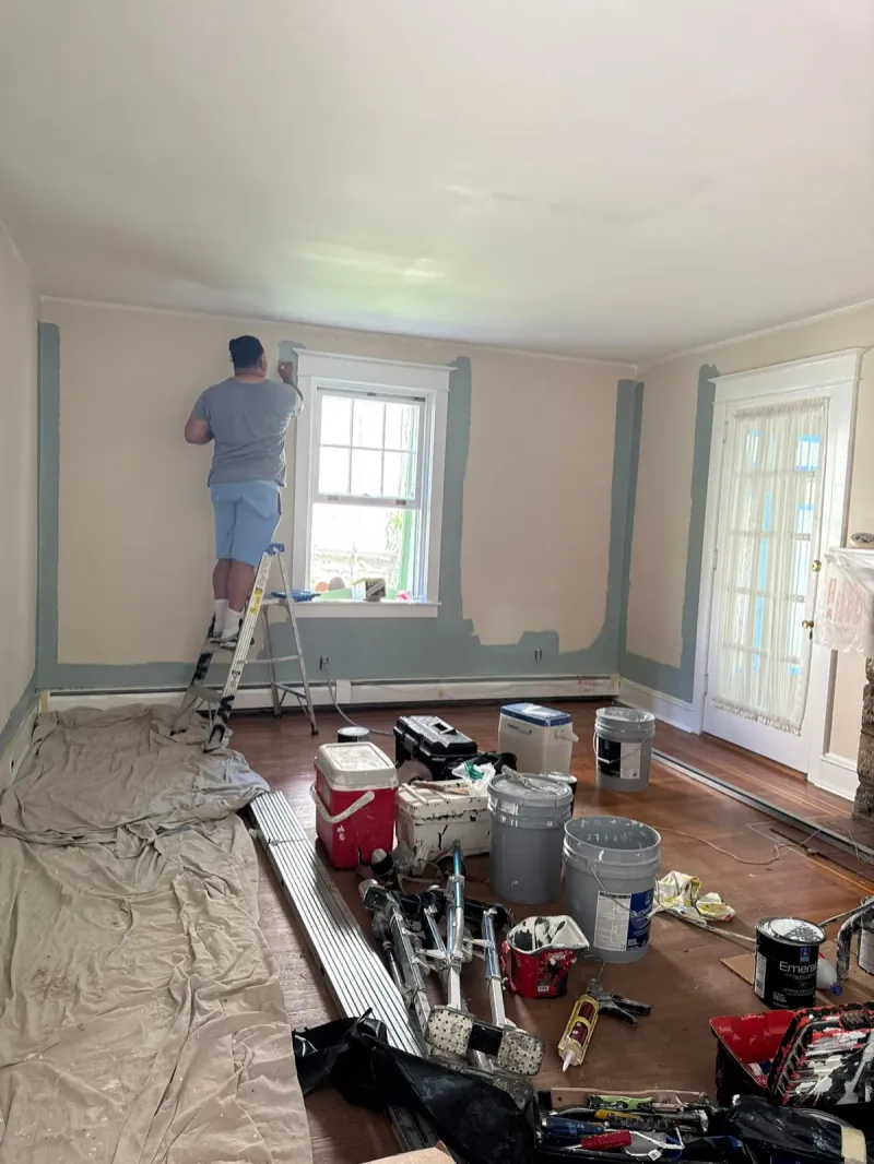 Painter repairing and prepping walls before interior painting