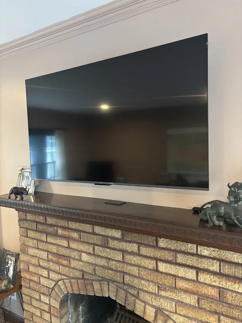 TV mounted above a brick fireplace