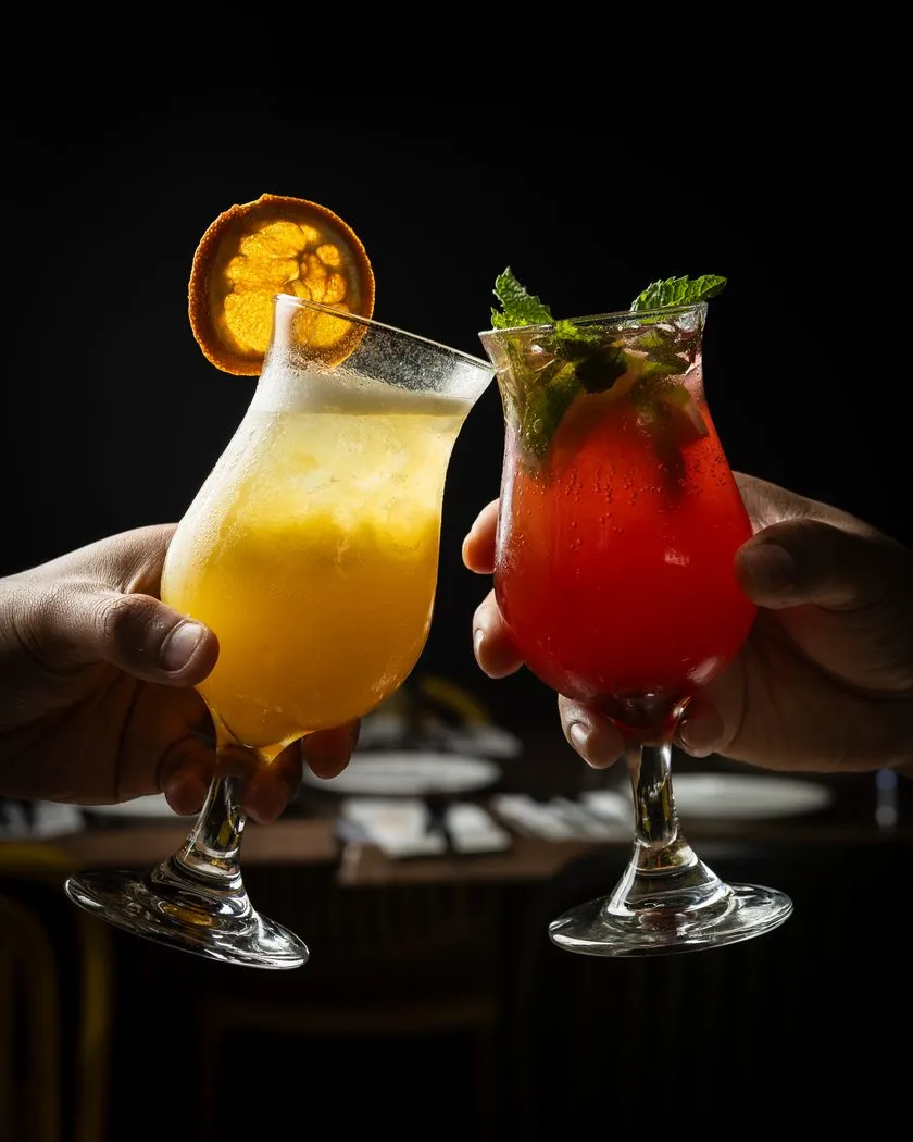 Two cocktails clinking in a cheers