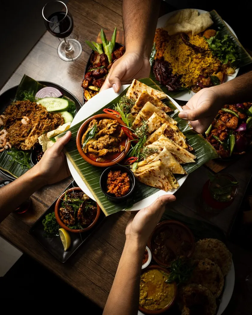 Friends sharing plates of Sri Lankan food around the table