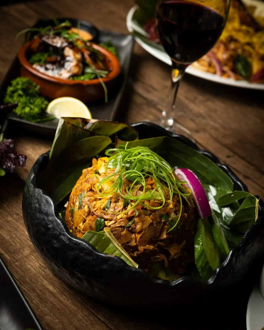 Fried rice in a black bowl garnished with spring onion