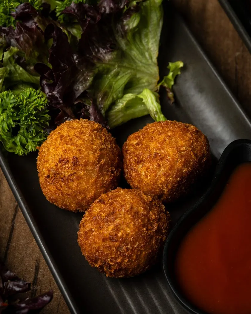 Three Sri Lankan fish cutlets with salad and dipping sauce