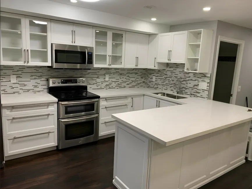 White kitchen with large island, mosaic backsplash and stainless appliances