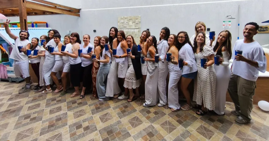 Equipe do Instituto PróDenver reunida, sorrindo e segurando canecas azuis