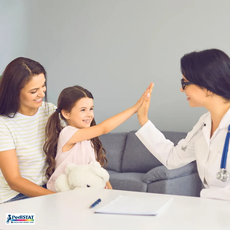Young girl giving her doctor a high five during a kids urgent care visit in Webster, TX