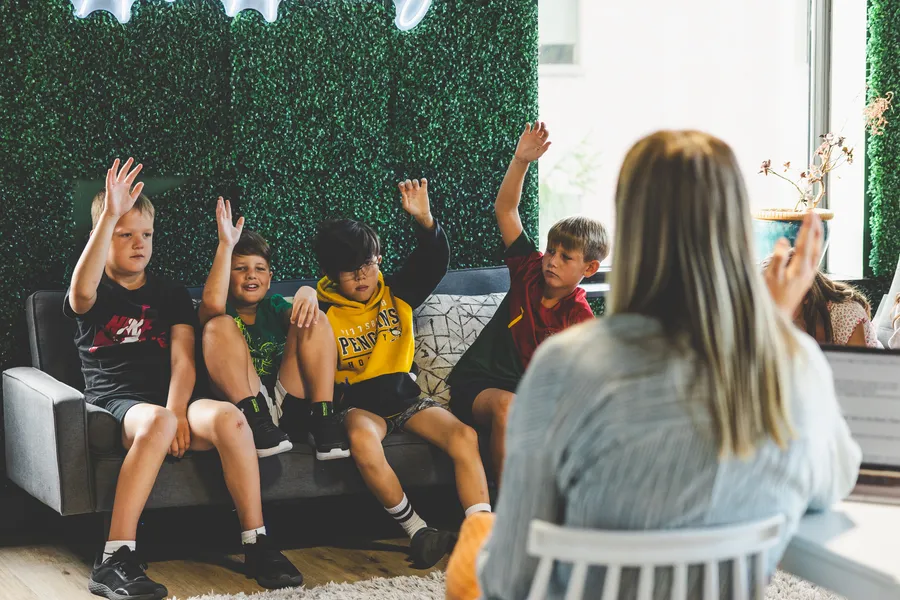 Acton learners raising their hands during a discussion