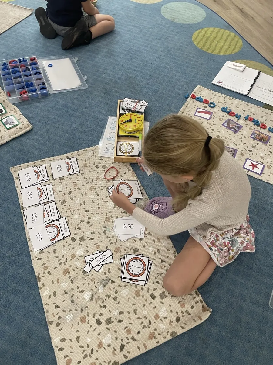 A Spark learner working with hands-on materials on a rug