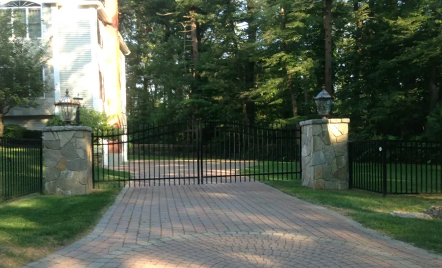 Custom black metal driveway gate by All Fenced In