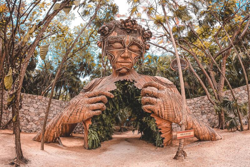 Large carved wooden figure among jungle trees