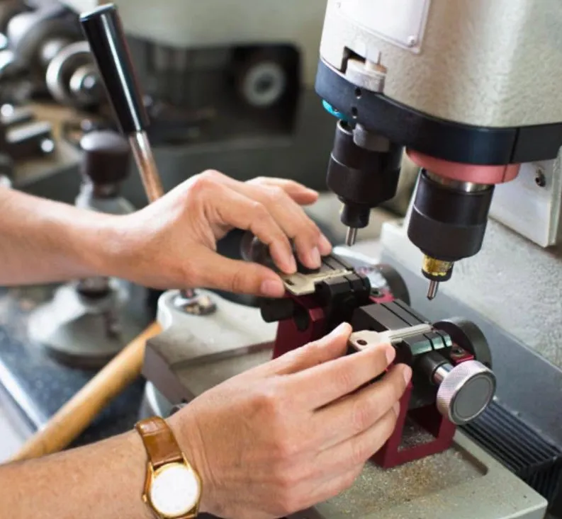 Locksmith cutting a new key on a key cutting machine