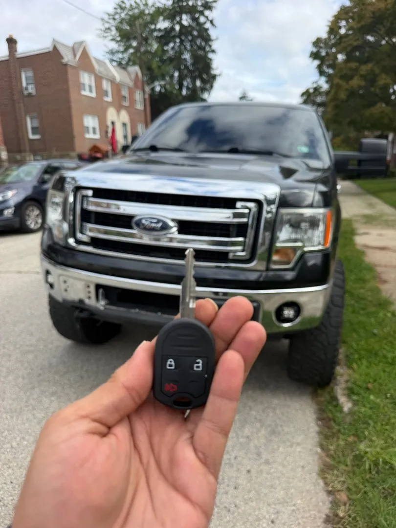 New key held up in front of a Ford pickup truck