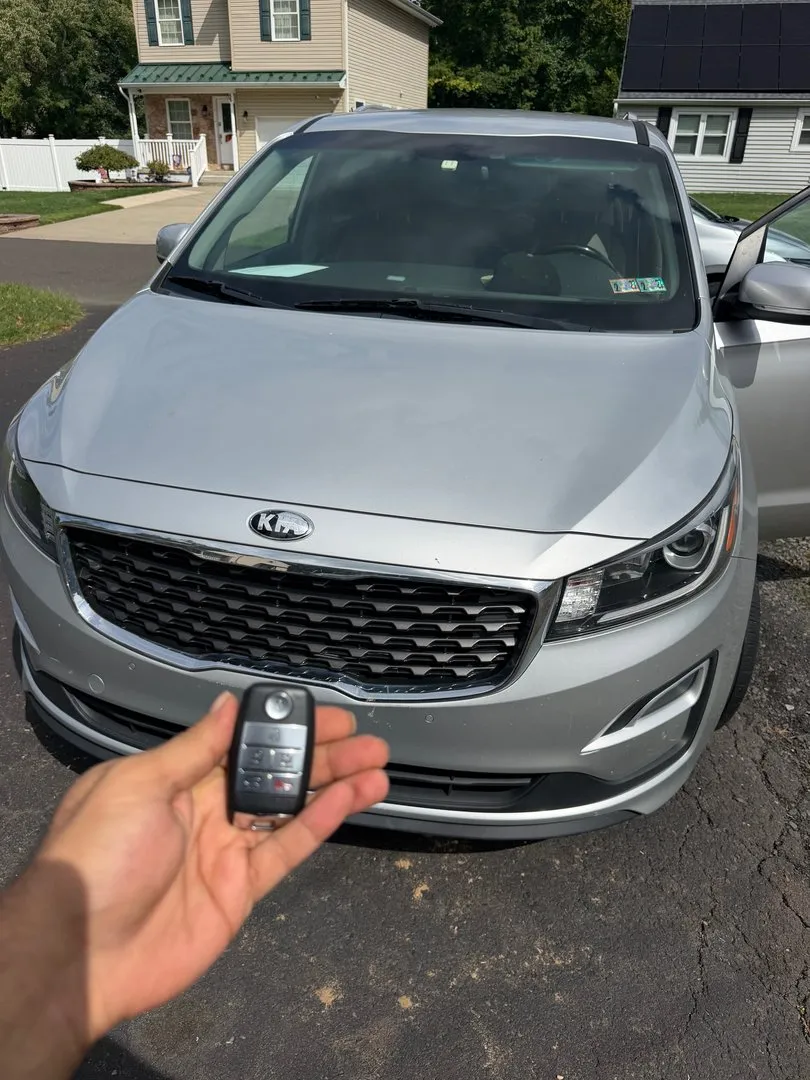 New key for a Kia minivan parked outside a home