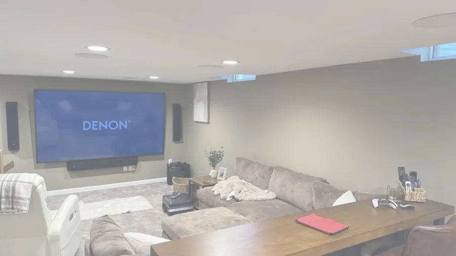 Basement home theater with a large screen, sectional and surround speakers