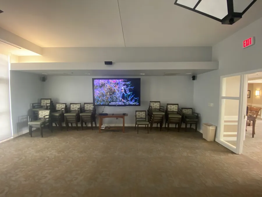 Community room with a large wall-mounted TV and rows of chairs