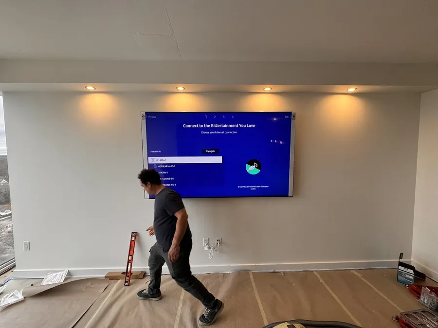 Large TV mounted on a living room wall during installation
