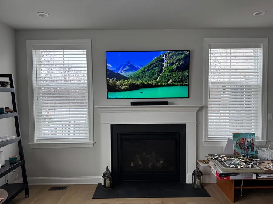 TV and soundbar above a white fireplace between two windows