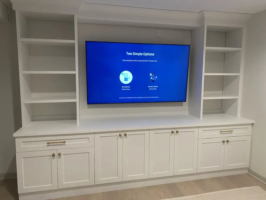 TV set into white built-in cabinetry and shelving