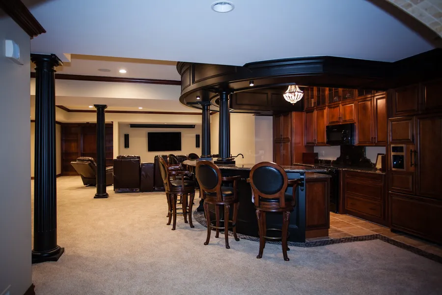 Finished basement with a wet bar, seating area and wall-mounted TV