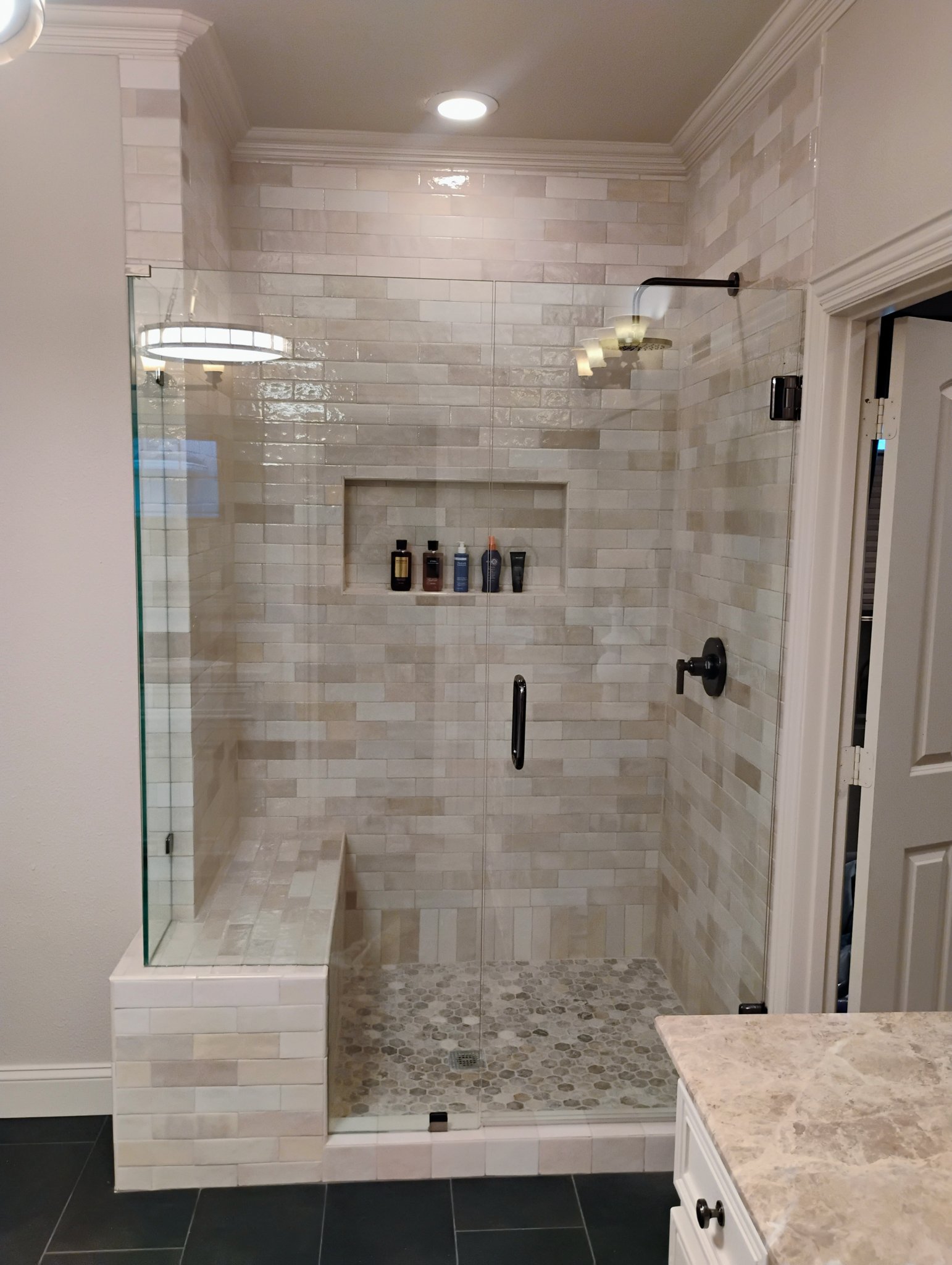 Walk-in shower with bench and chandelier