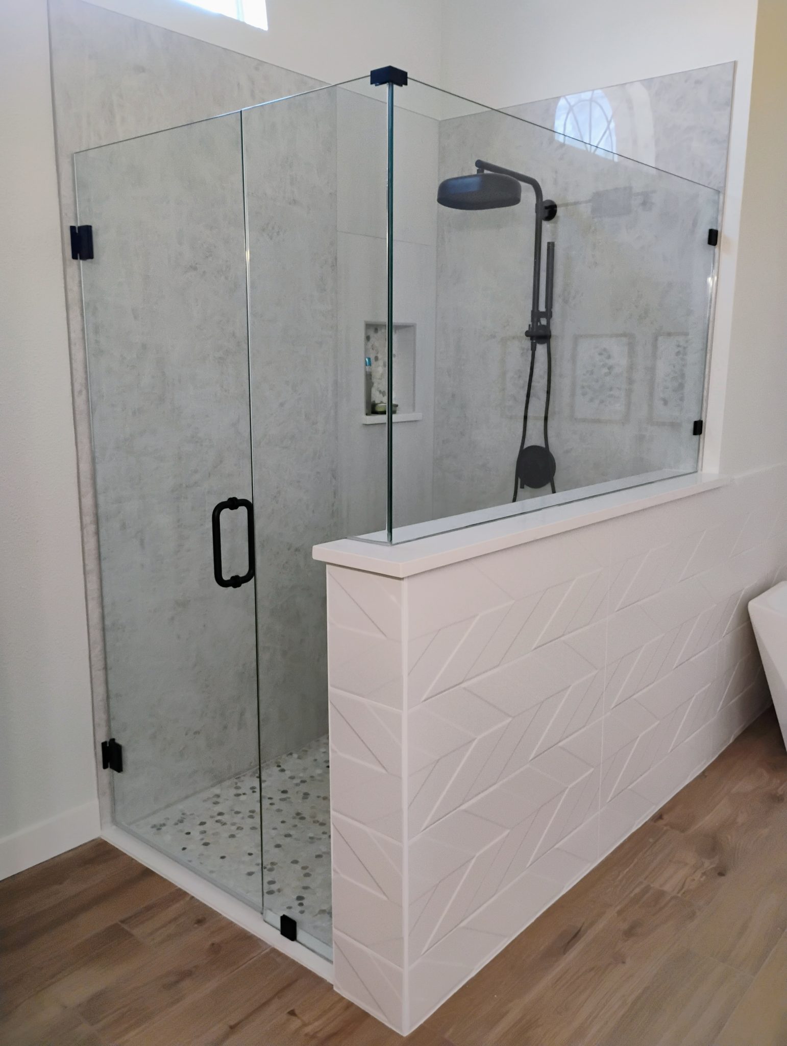 Half-wall shower glass with black chevron tile