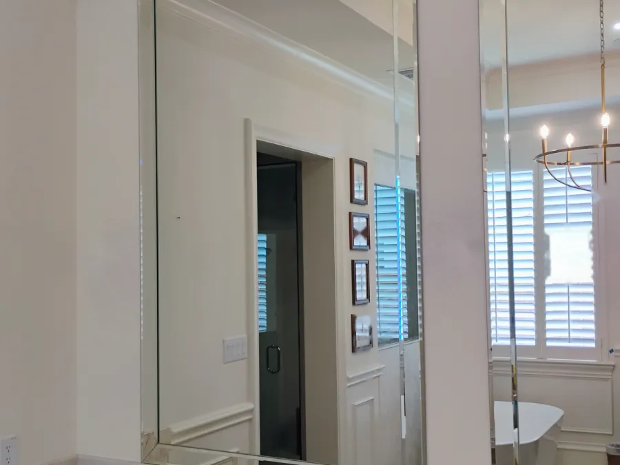 Full mirror wall over marble in a DFW bathroom