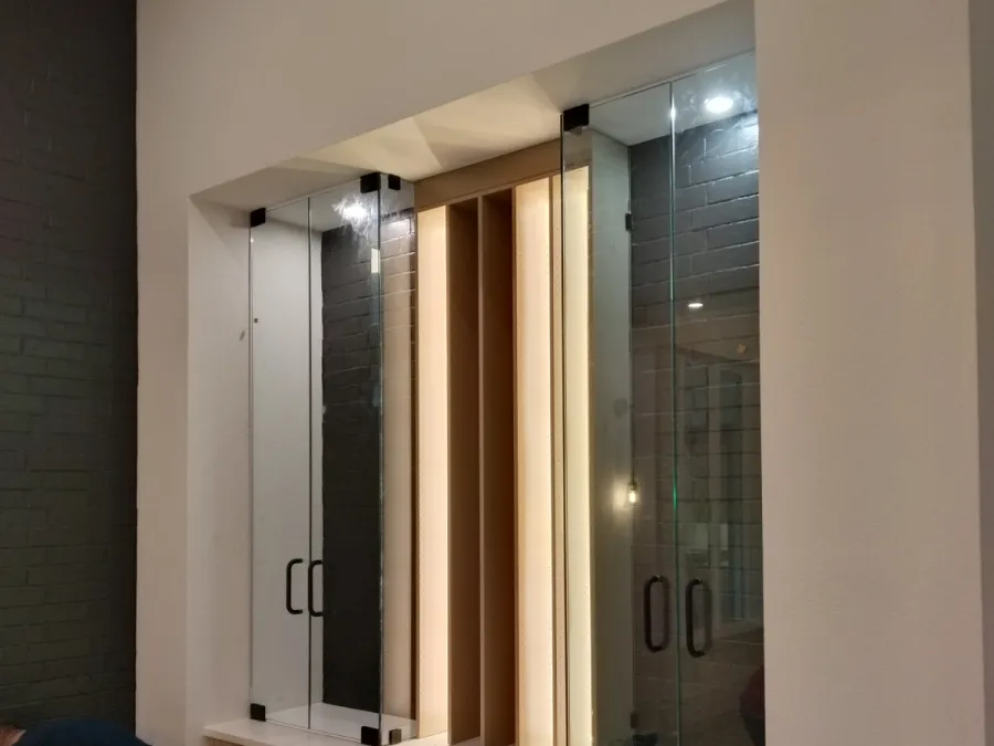 Frameless glass wine-room door with lit shelving, DFW home