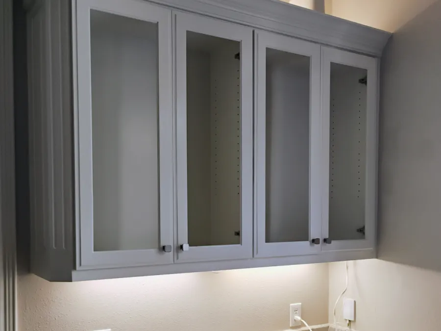 Gray upper cabinets with clear glass doors