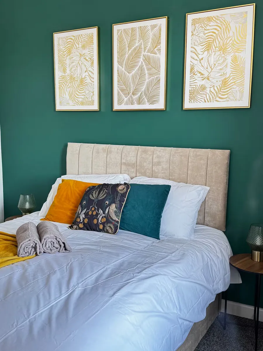 King-size bedroom with teal feature wall at the Flow Stays home in Worsbrough, Barnsley