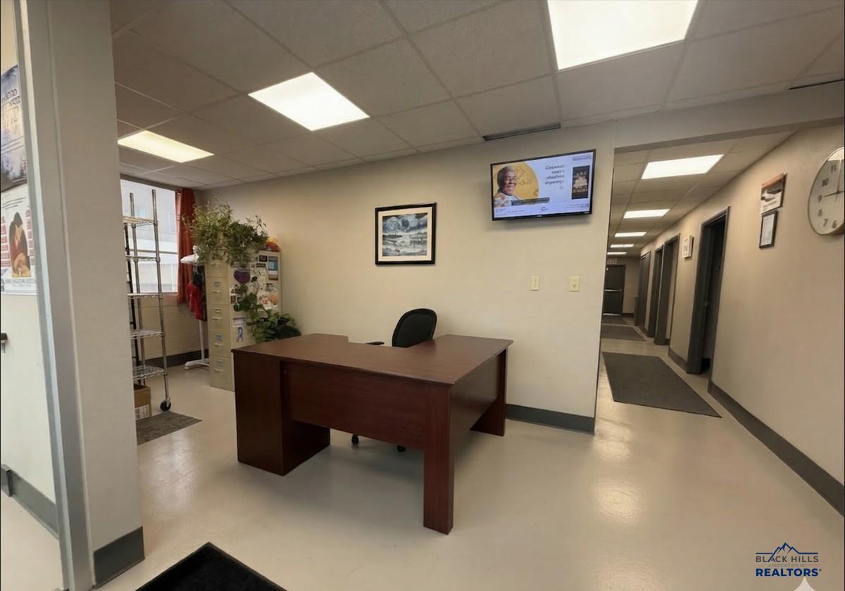 Reception area with a desk and a hallway leading to the private offices