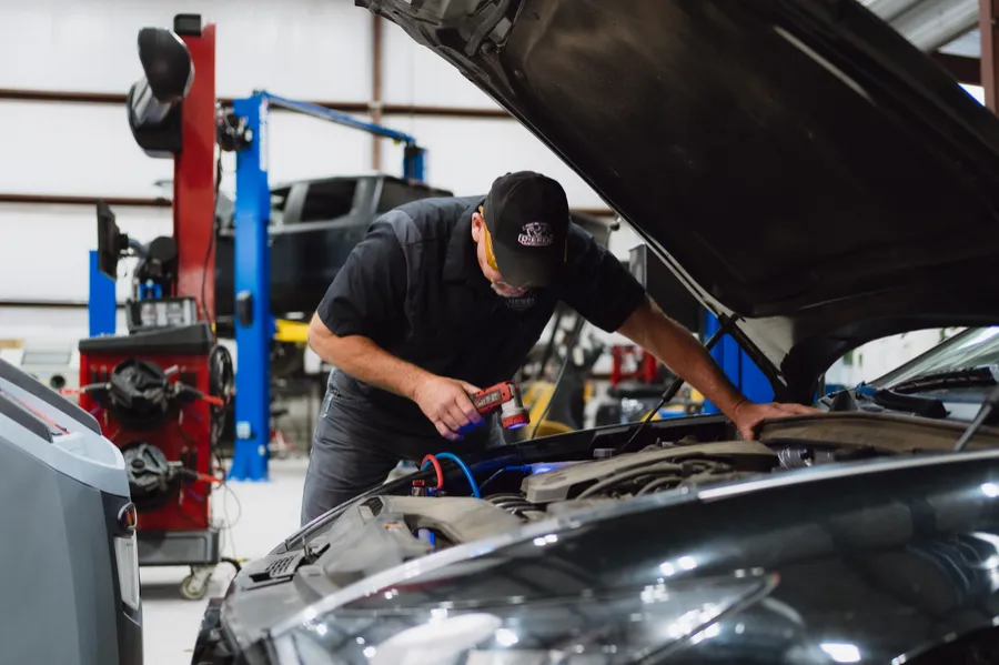 Technician diagnosing an engine under the hood