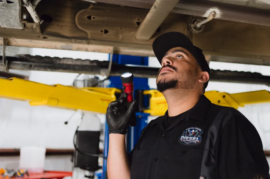 Technician inspecting the underside of a truck