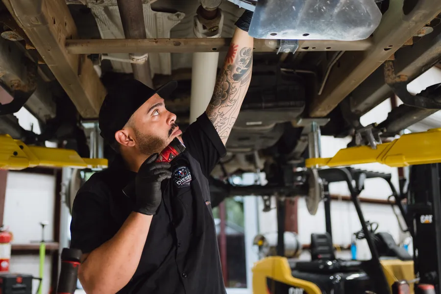 Technician working under a truck on the lift