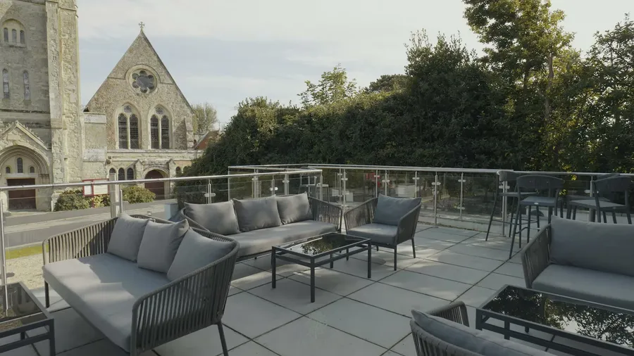 Outdoor terrace with sofas beside the church at The Fig Tree, Shanklin