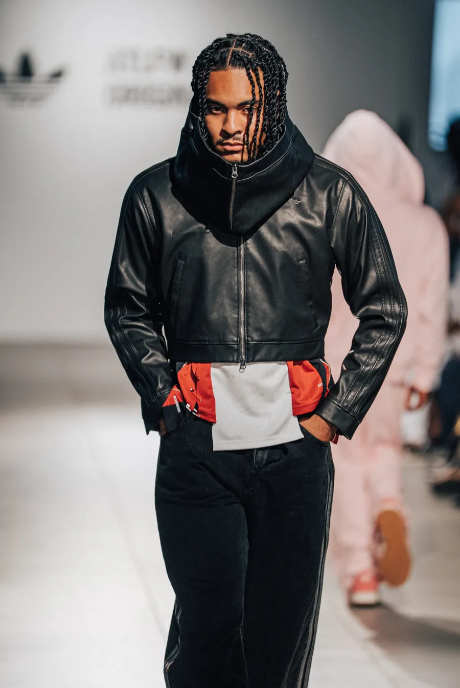 Model in a black leather jacket walking toward camera