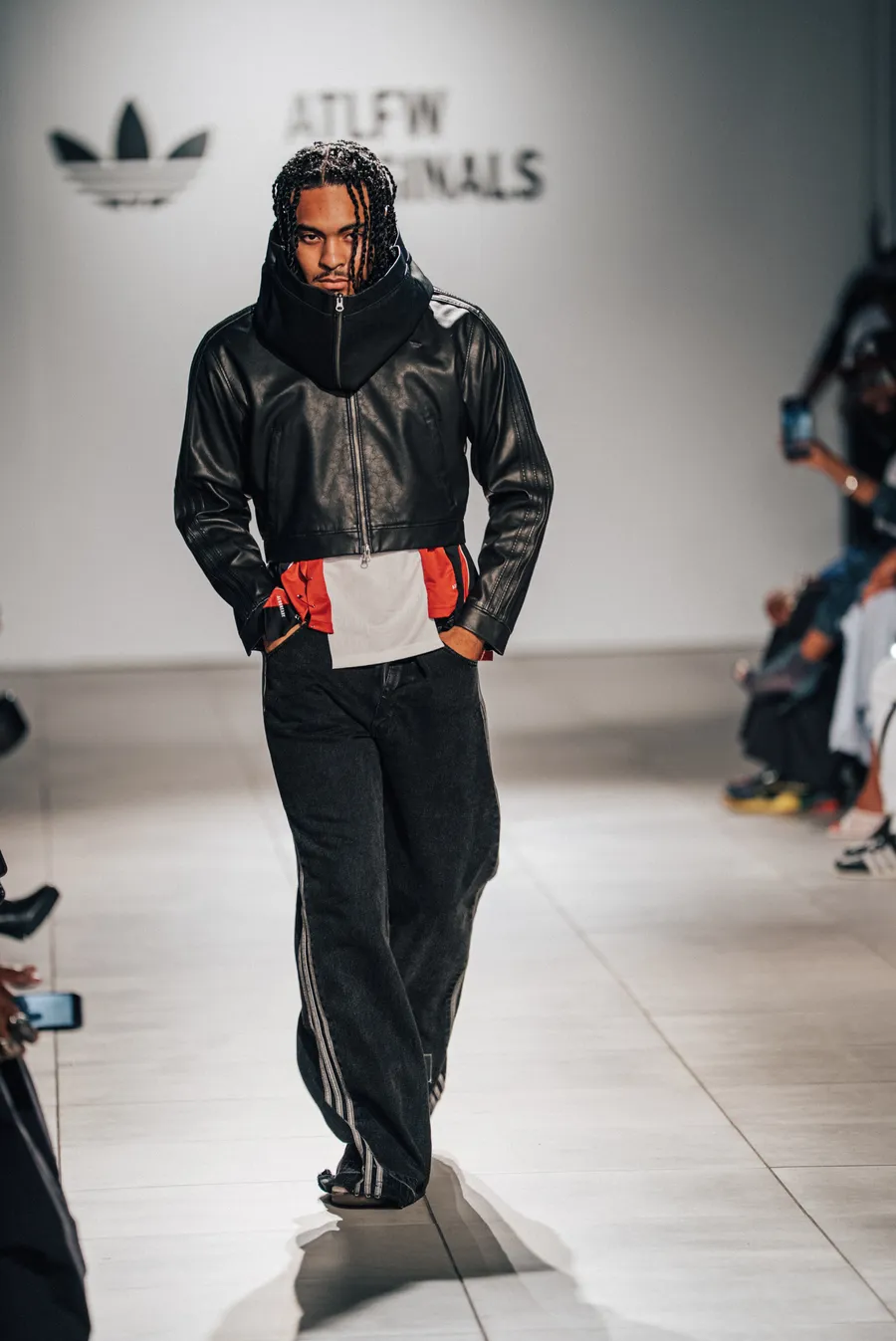 Model in a black jacket and slacks on the runway