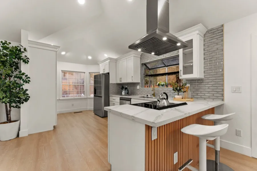 Kitchen remodel with wood-slat peninsula and stone counters