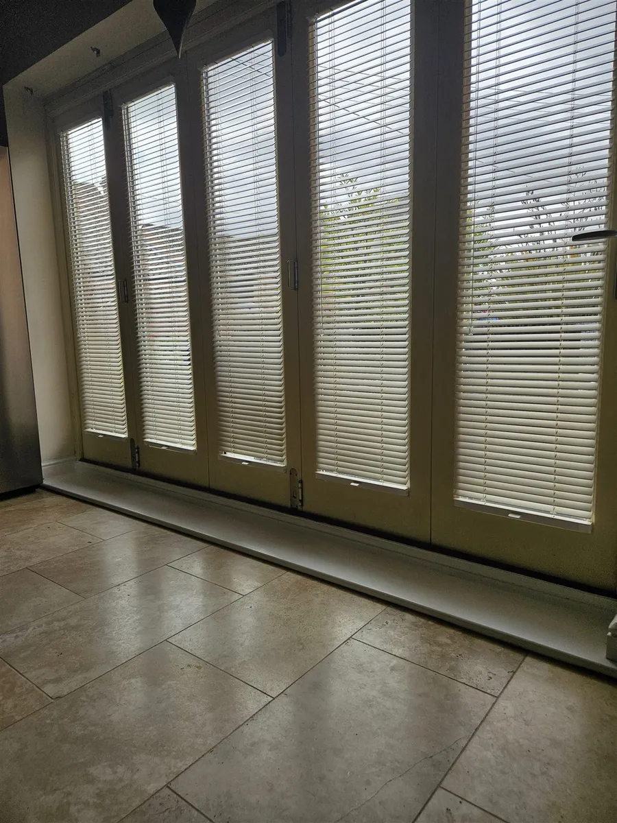 Cream wood venetian blinds fitted to each pane of bi-fold doors by Eclipse SBC in Woodhall Spa
