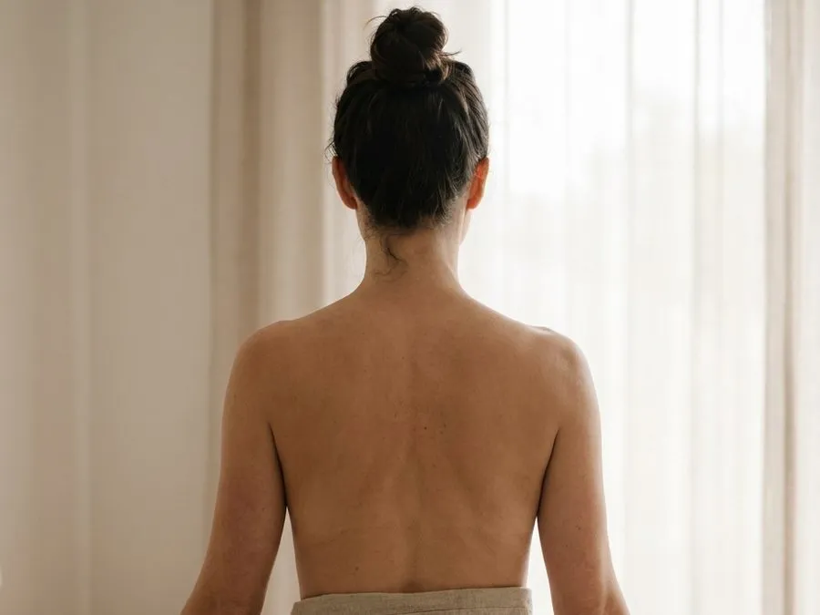 Ombros e costas de uma mulher sob luz natural