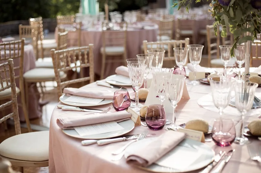 Bridal shoes and bag laid out on a bed